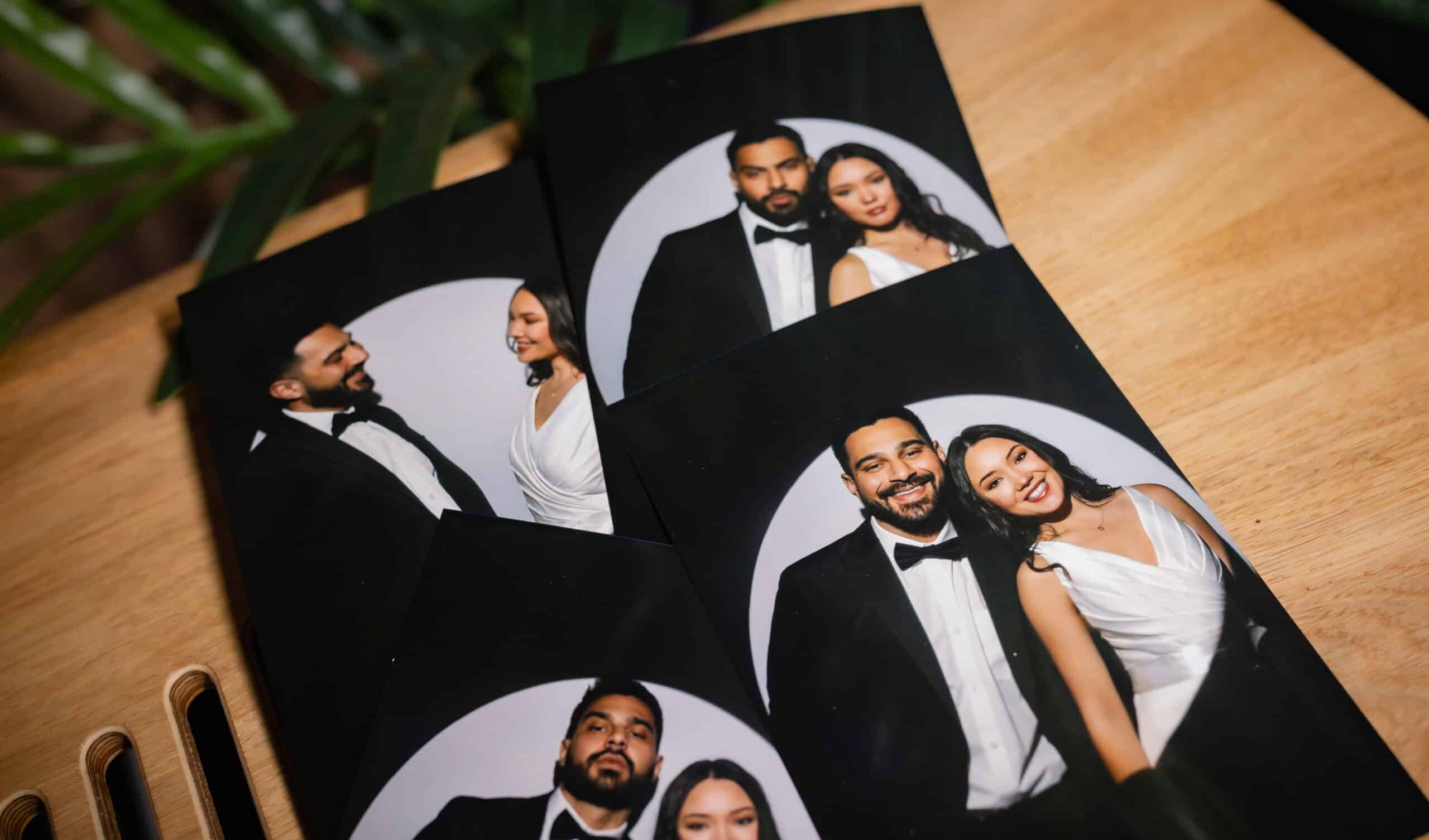 Spotlight photo booth prints set on a wooden table