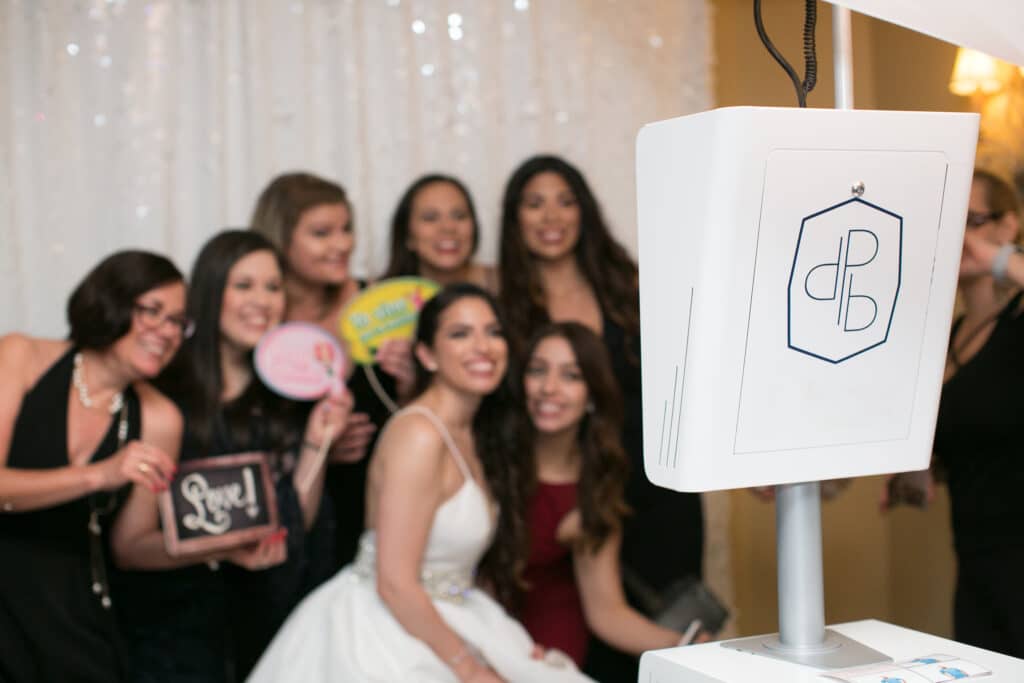 Bride and her party posing for a photo with an open air photo booth