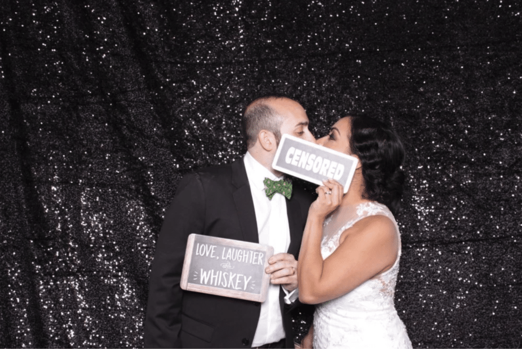 Bride and groom holding photo booth signs