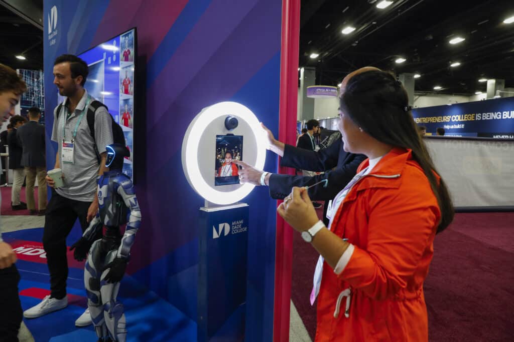 Woman in red blazer interacting with a photo booth setup