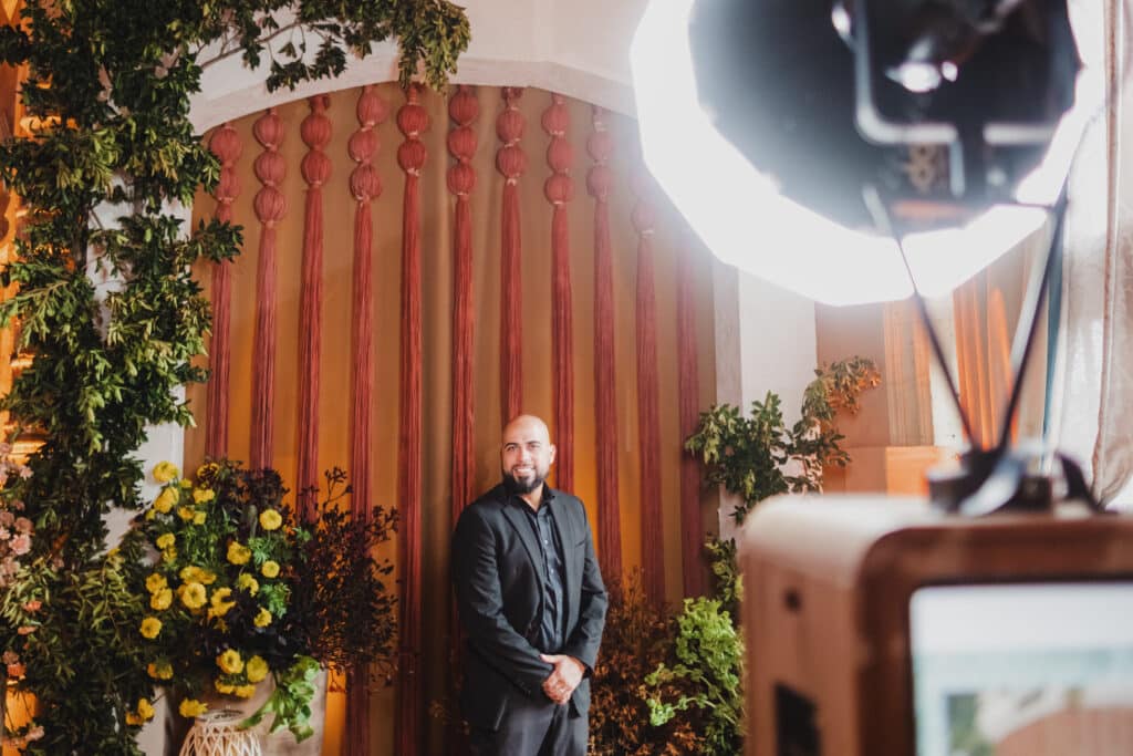 Man posing for a photo with an open air photo booth