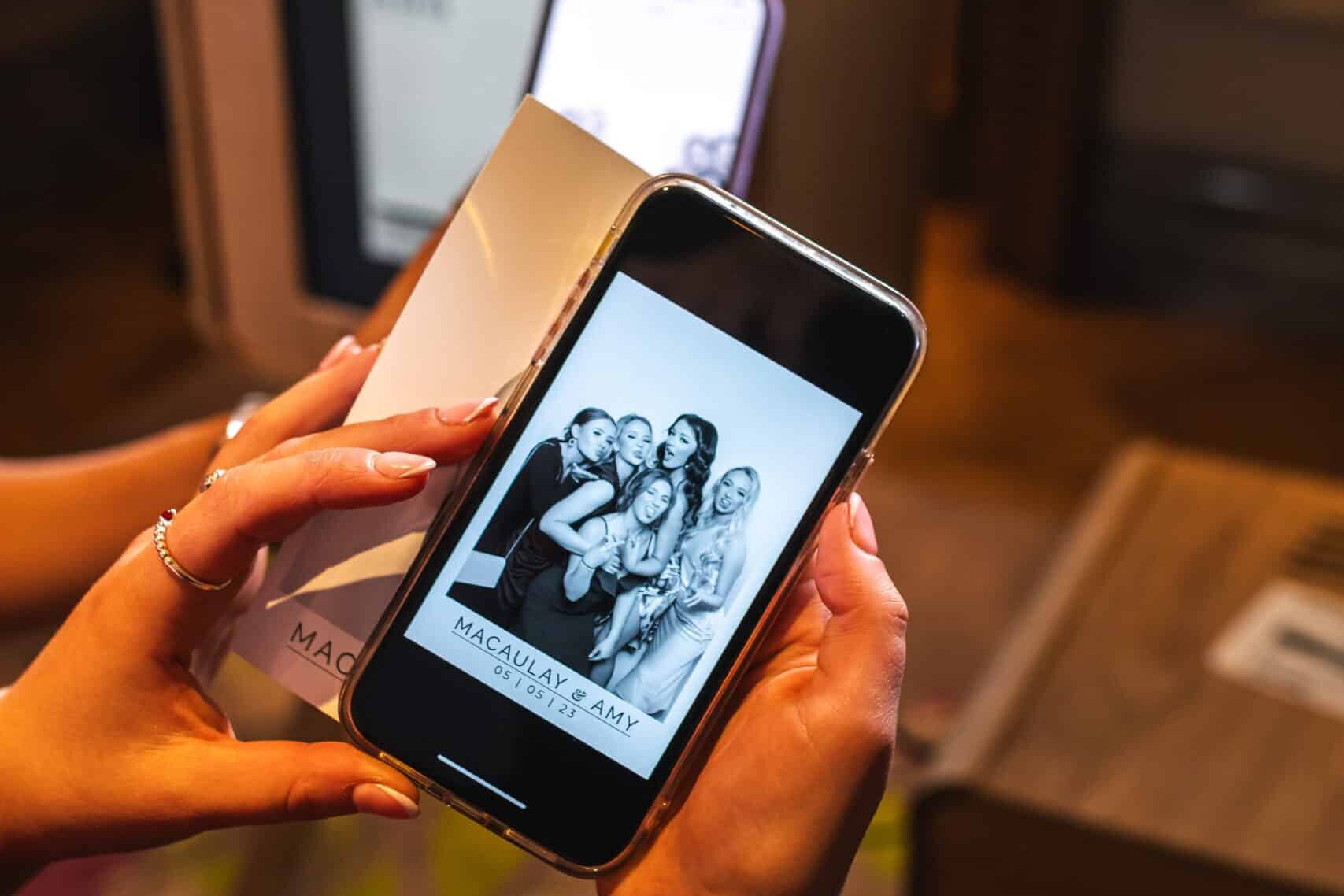 The ladies looking at their photos on their mobile phones taken by the Everybooth and sent